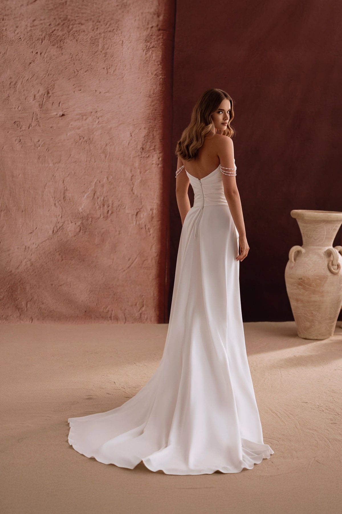 Robe de mariée Eleonore, avec un décolleté aux épaules dénudées, de souples fronces et des touches de perles.