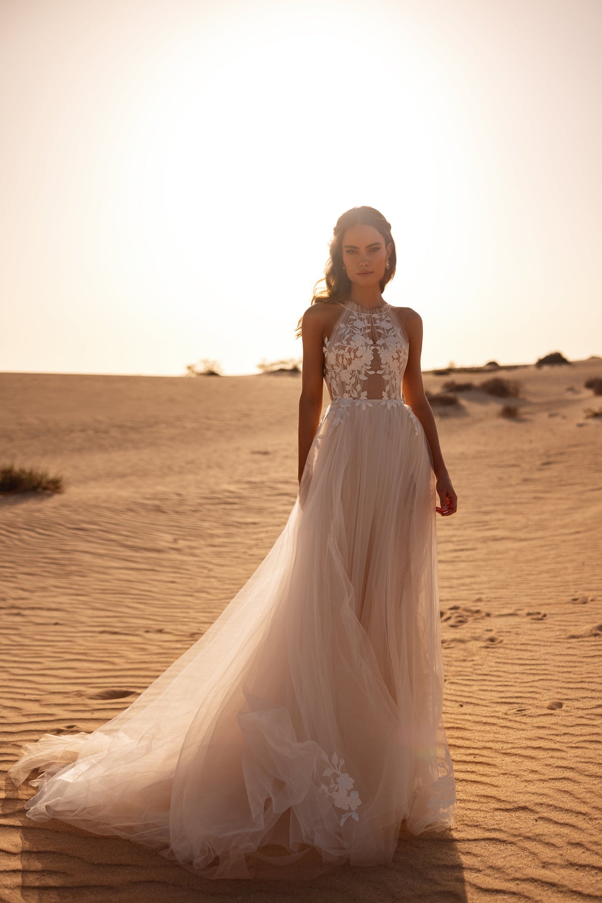 Robe de mariée Ellie, avec un corsage illusion à encolure américaine et une jupe fluide en tulle ornée d’appliqués floraux.