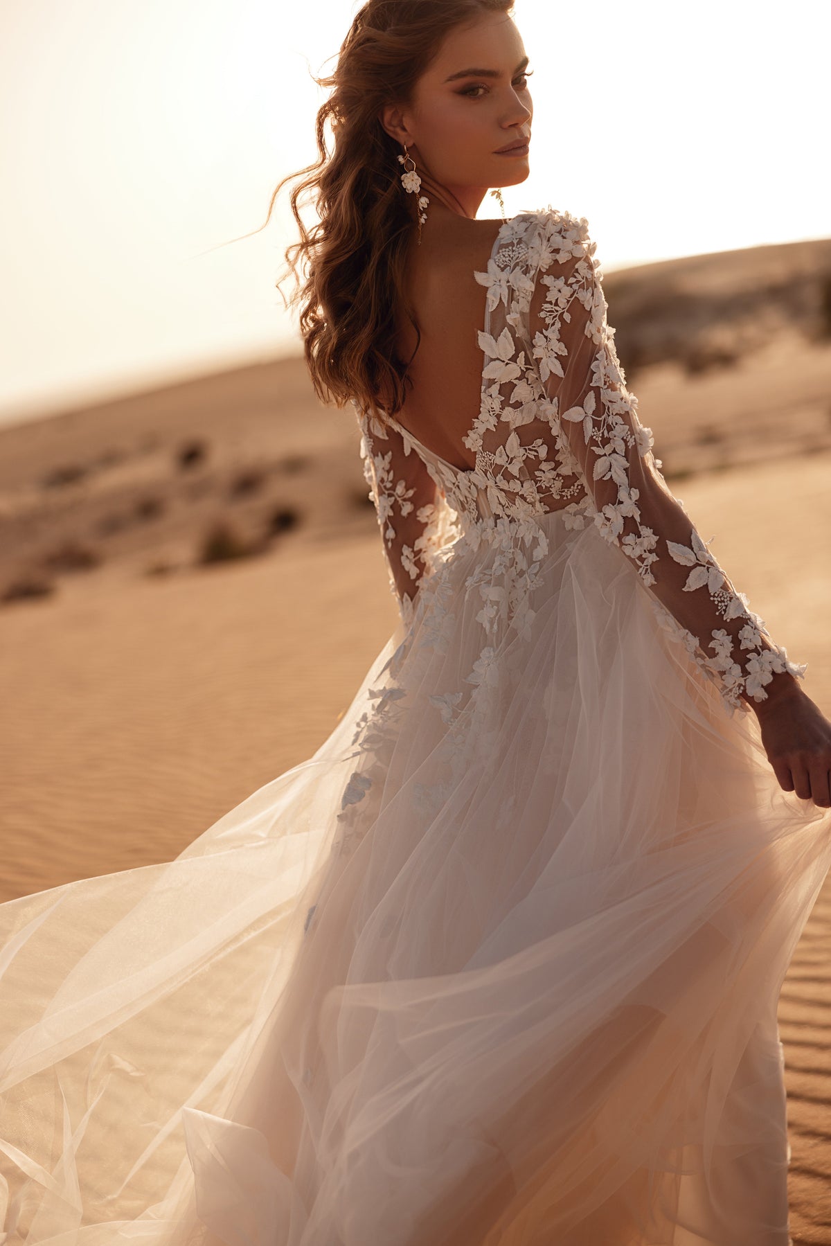 Robe de mariée Farida, avec sa dentelle florale en relief et ses couches de tulle au coucher du soleil.