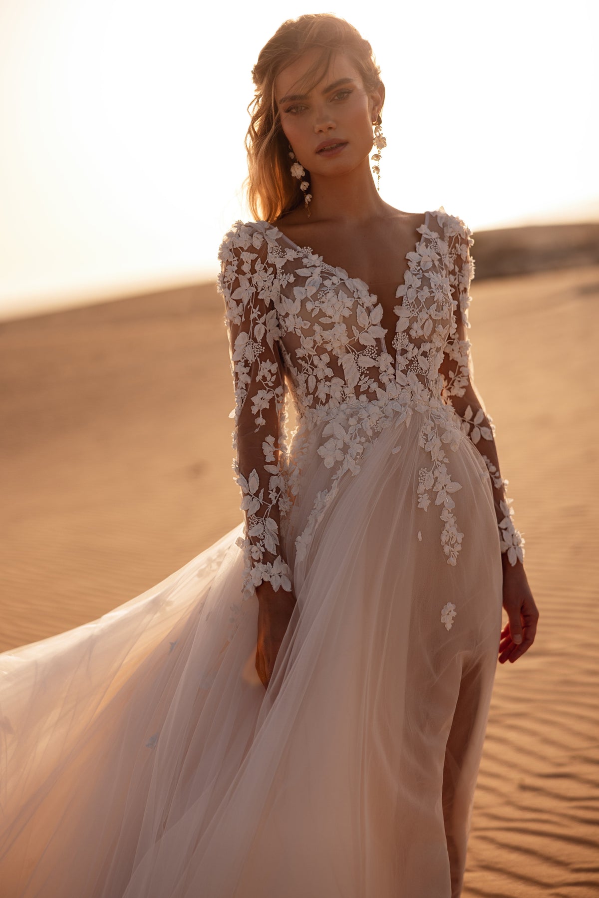 Robe de mariée Farida, avec un décolleté en V profond, de longues manches en dentelle et des appliqués floraux en relief.