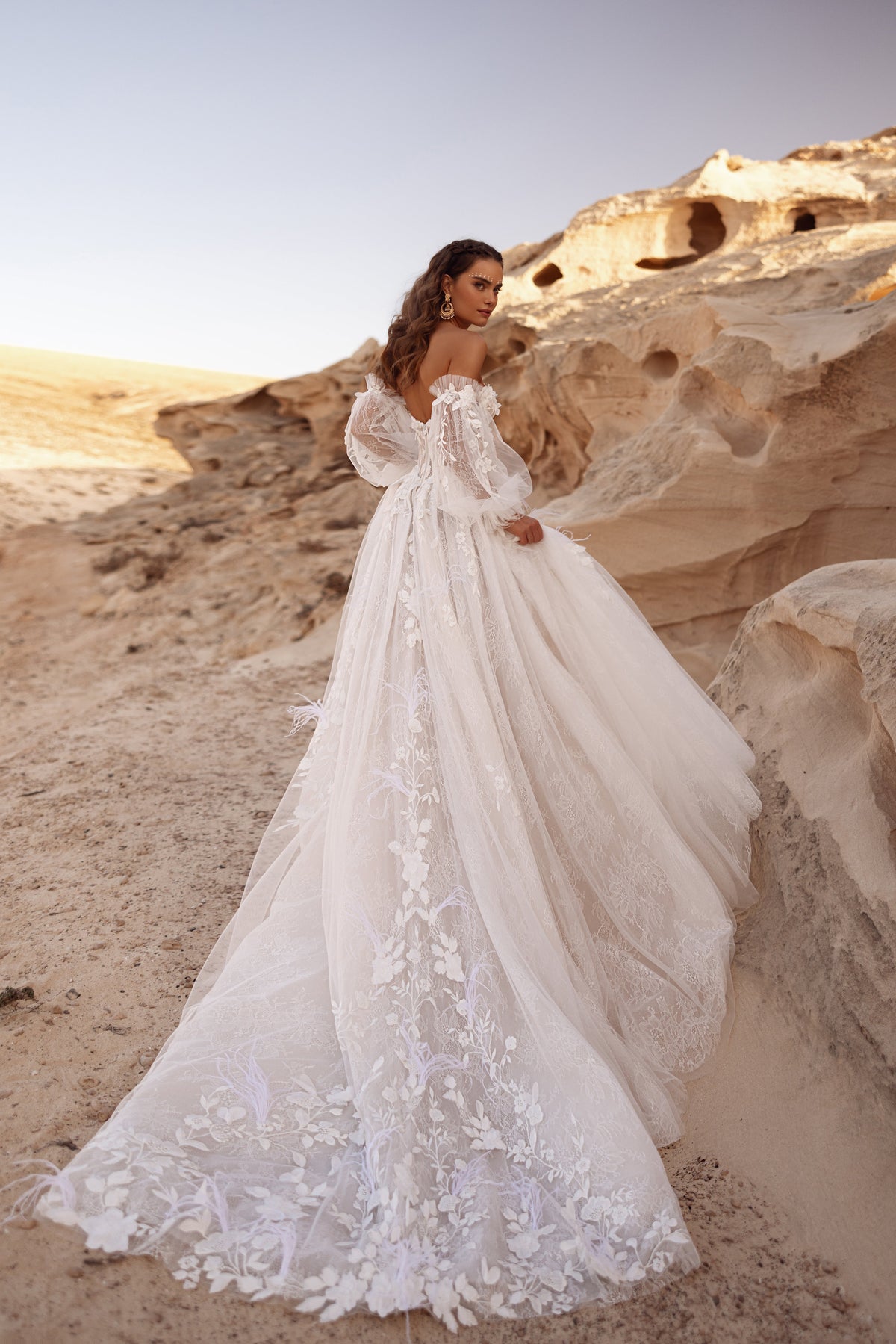 Robe de mariée Huda, avec une traîne brodée de fleurs et une jupe de tulle superposé.