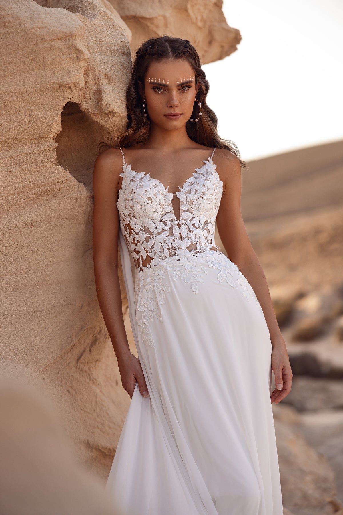 Robe de mariée Malika, avec une traîne en dentelle à motifs de feuilles.