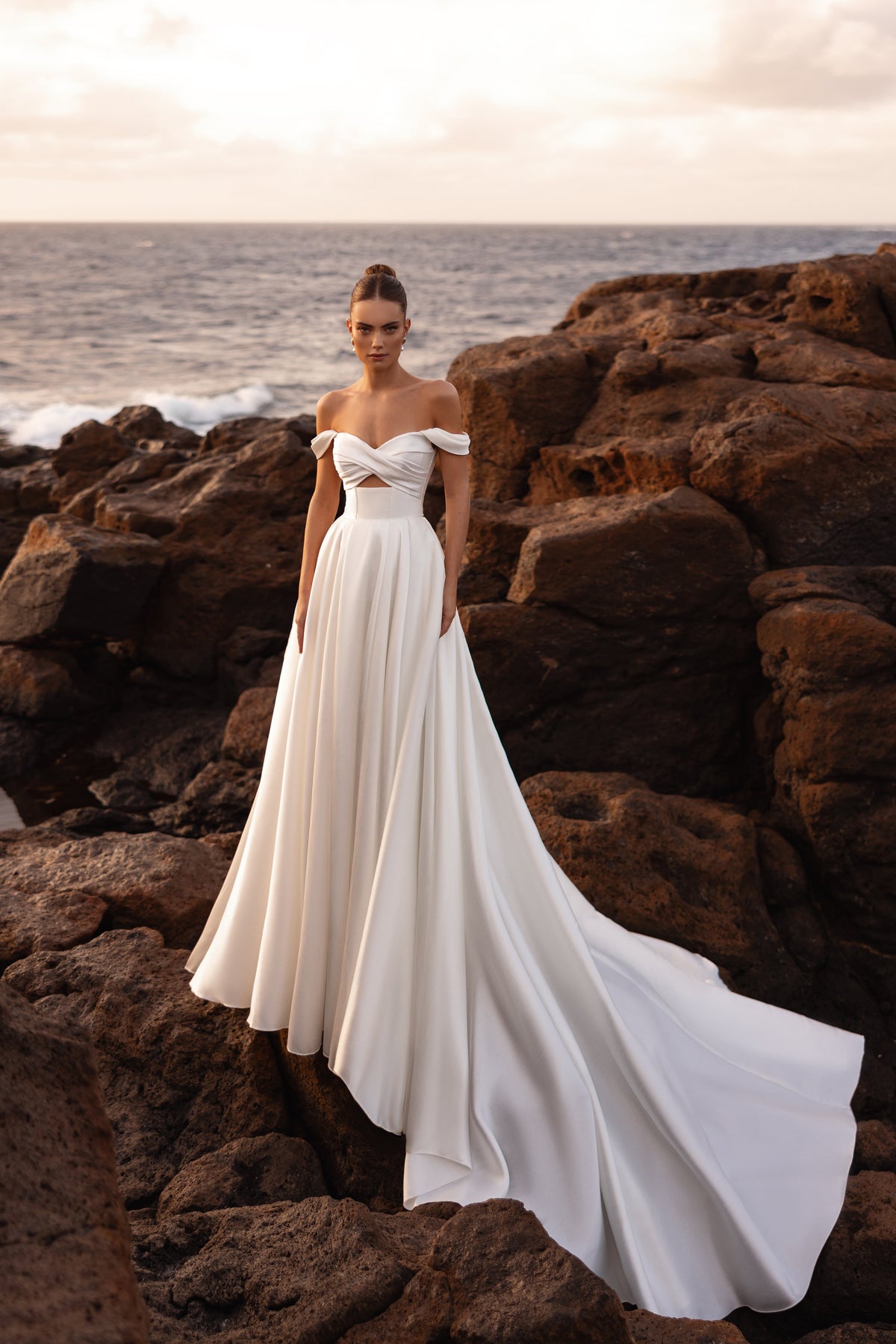 Robe de mariée princesse Mellisandre, avec les épaules dénudées et une traîne fluide.
