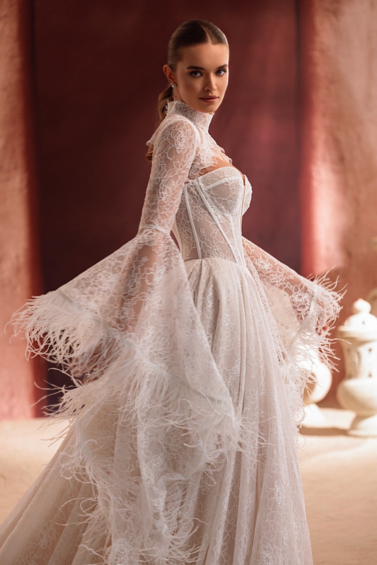 Boléro de mariée Michelle en dentelle, à manches transparentes et col montant, porté avec une robe de mariée.
