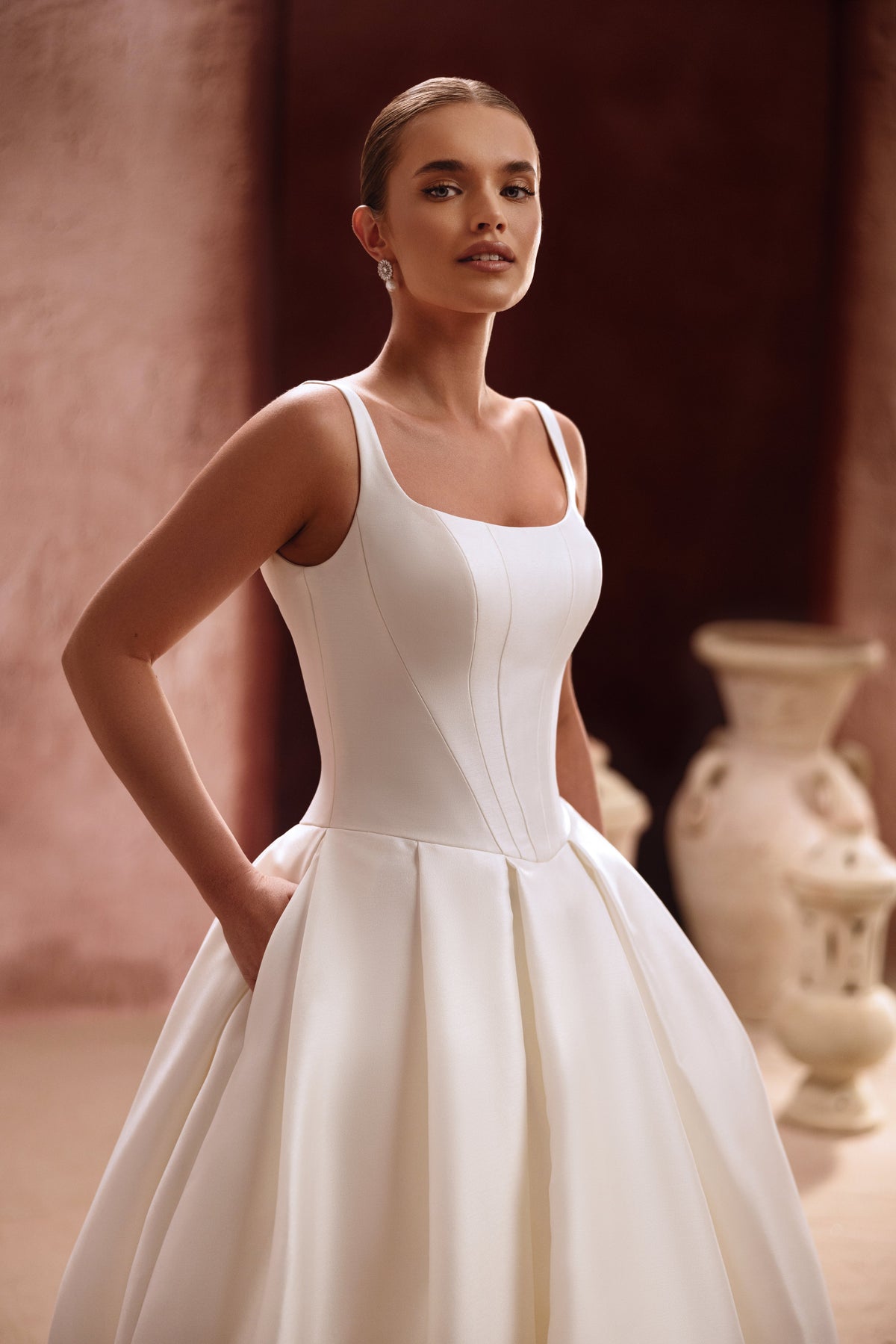 Robe de mariée Nicolette, avec un corsage épuré en satin à bretelles et une volumineuse jupe princesse.