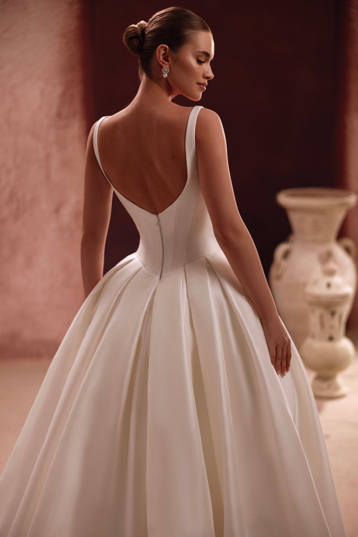 Robe de mariée Nicolette portée avec un voile en tulle orné de grandes fleurs.