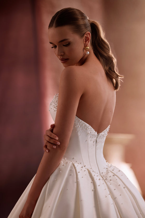 Robe de mariée Noor en satin brillant, avec une jupe ample et une traîne.