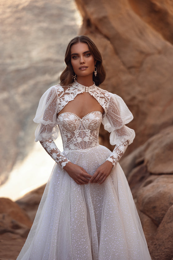 Robe de mariée Oasis en dentelle, avec des manches bouffantes et une jupe en tulle transparent.