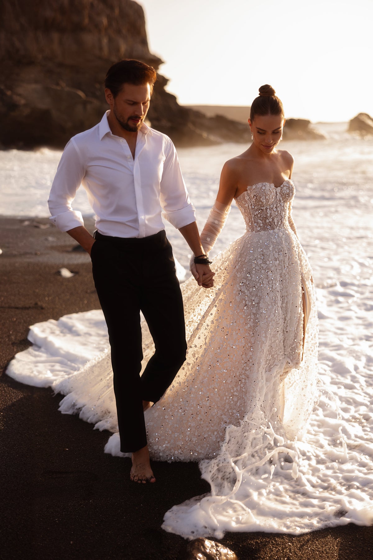 Robe de mariée Reem, avec un corset perlé, une fente devant et des sequins.