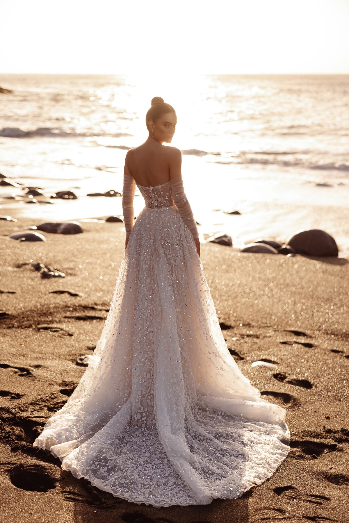 Robe de mariée Reem, avec un corset illusion et des ornements floraux en relief au coucher du soleil.
