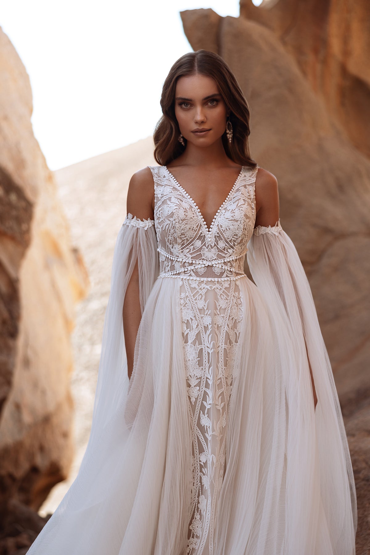 Robe de mariée Salome, avec les épaules dénudées, de longues manches en tulle et des détails de dentelle.