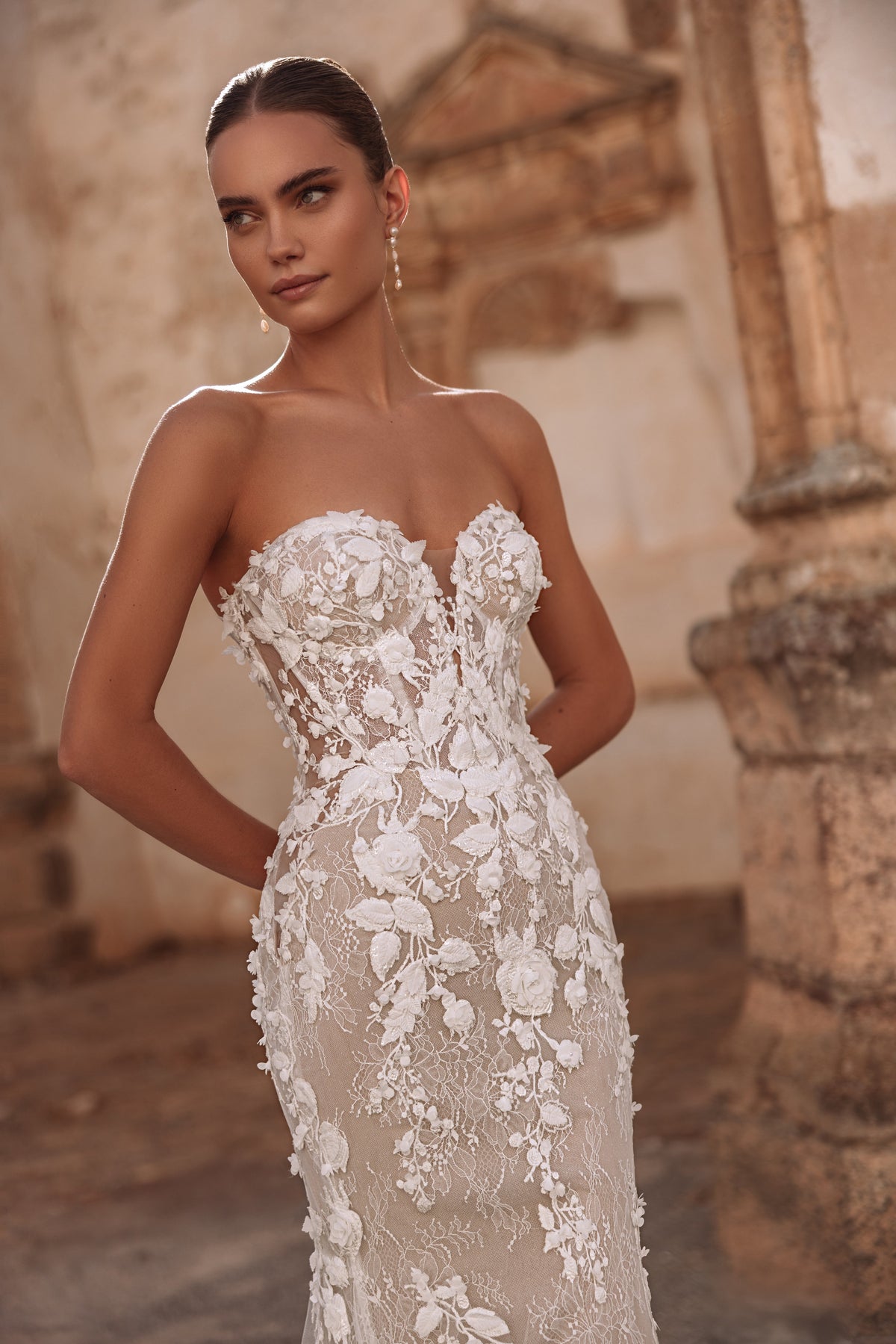 Robe de mariée Sarifa en dentelle, avec une traîne et des détails floraux.