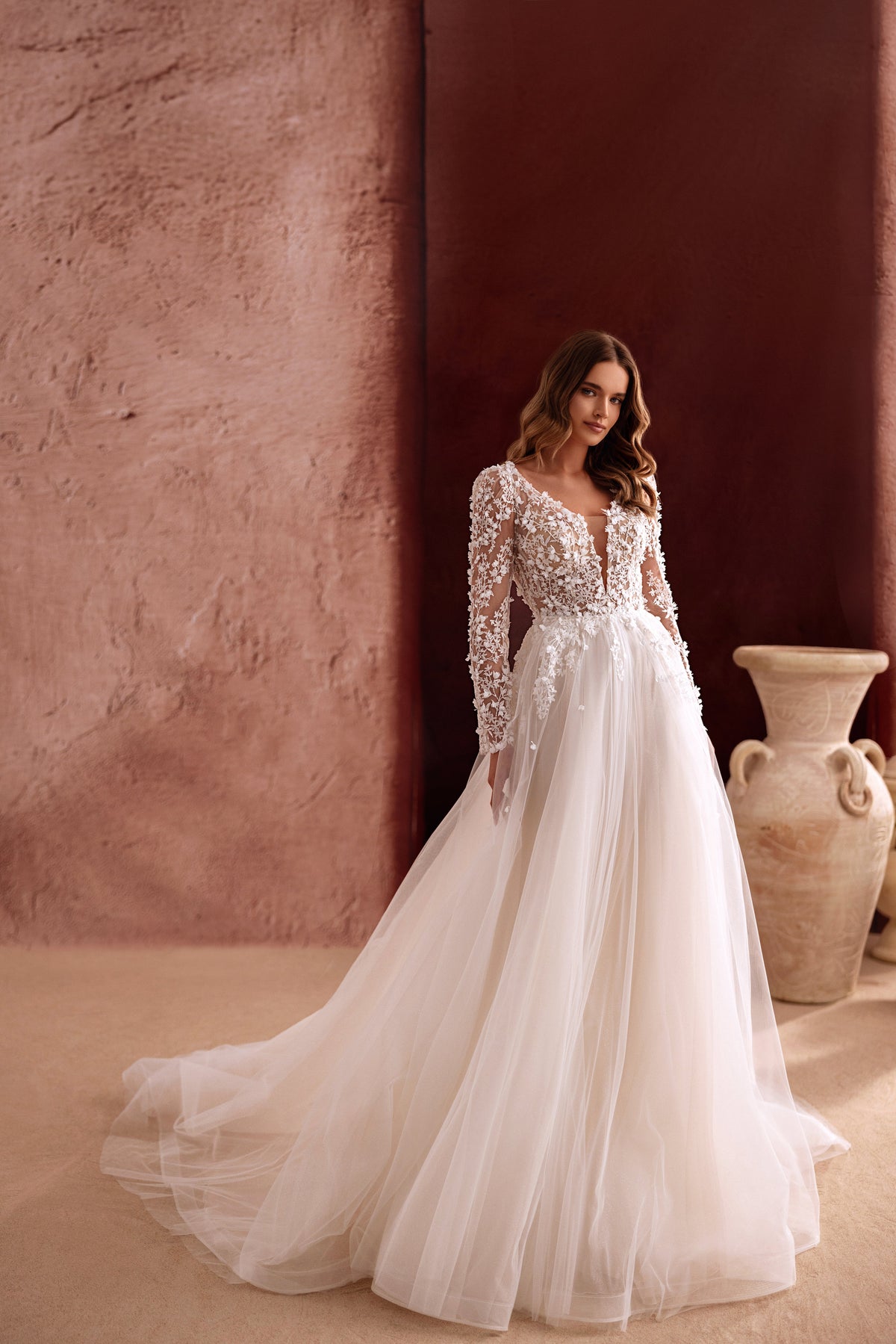 Robe de mariée Shanin, avec de longues manches en dentelle, un décolleté profond et une jupe fluide en tulle.