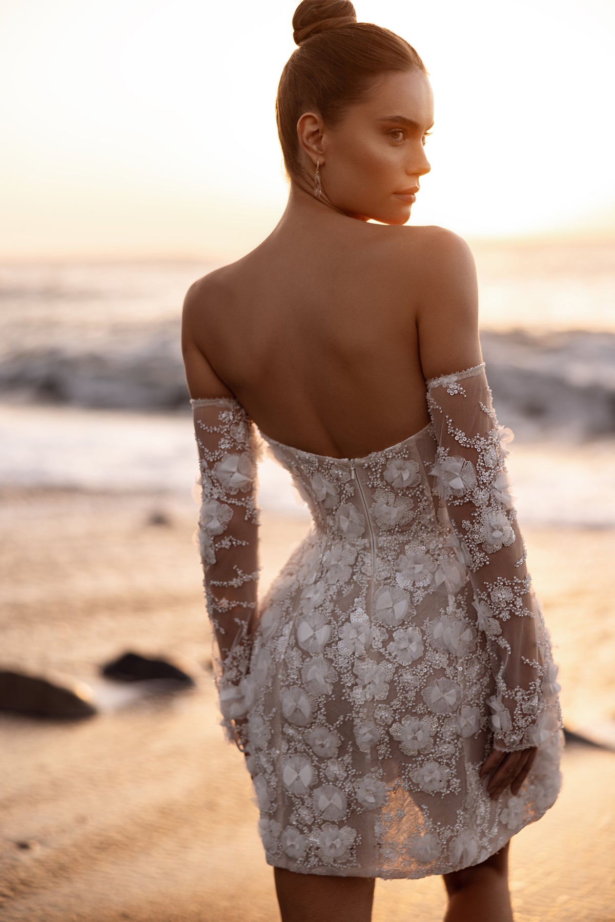 Robe de mariée Kayla, avec un décolleté cœur et des broderies de dentelle au coucher du soleil.