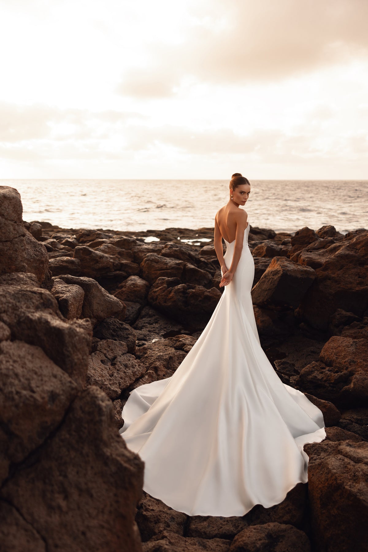 Robe de mariée Soraya sans bretelles, avec une silhouette épurée au fini satiné qui marque la taille.