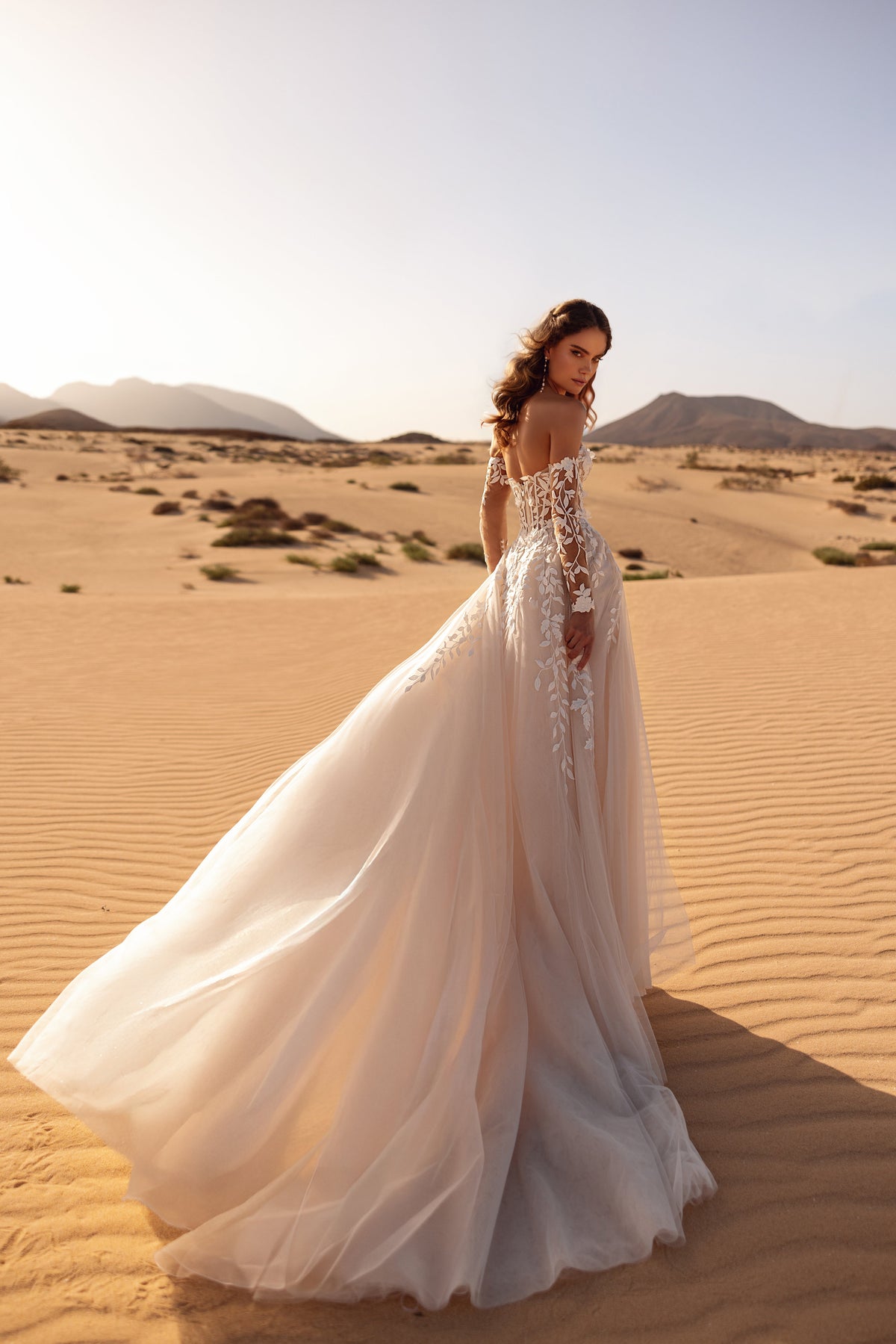 Robe de mariée Tamara, avec des manches en dentelle laissant les épaules dénudées.