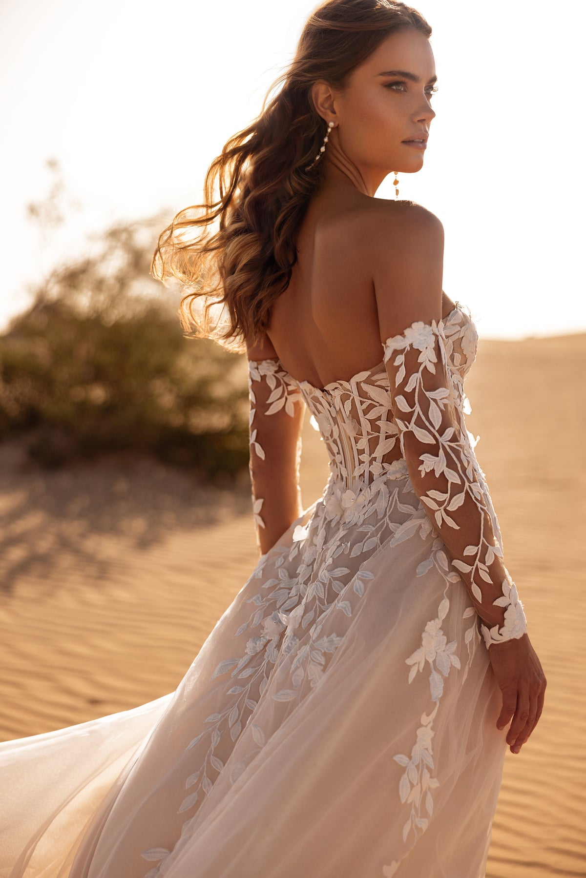 Robe de mariée Tamara, avec des manches laissant les épaules dénudées et des appliqués de dentelle florale.