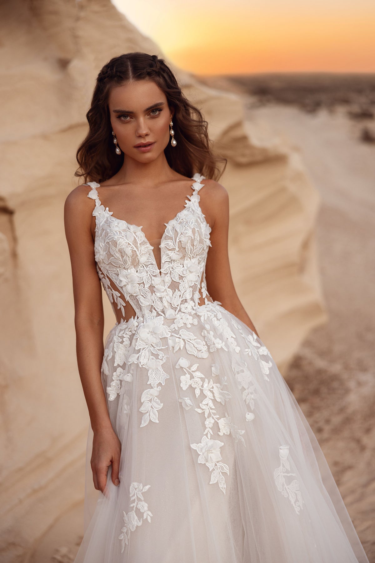 Robe de mariée Zafira, avec une jupe en tulle et des détails de dentelle florale, aux côtés d’un marié en costume beige.