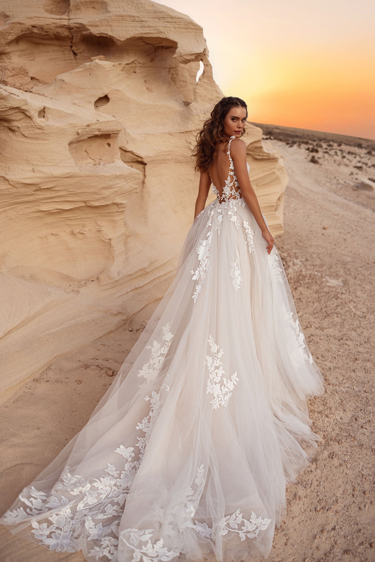 Robe de mariée Zafira, avec un dos nu et une longue traîne en tulle ornée d’appliqués de dentelle florale en relief.